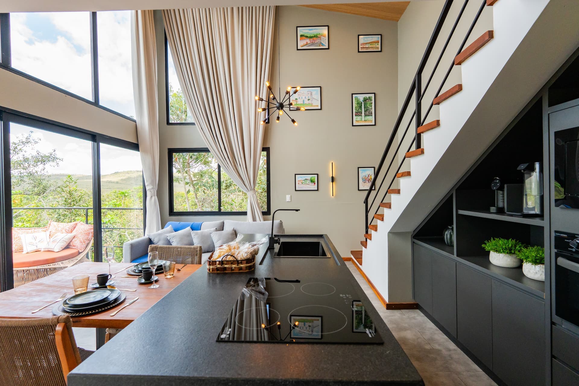 Ilha de cozinha com cooktop de indução e vista para a sala e a serra
