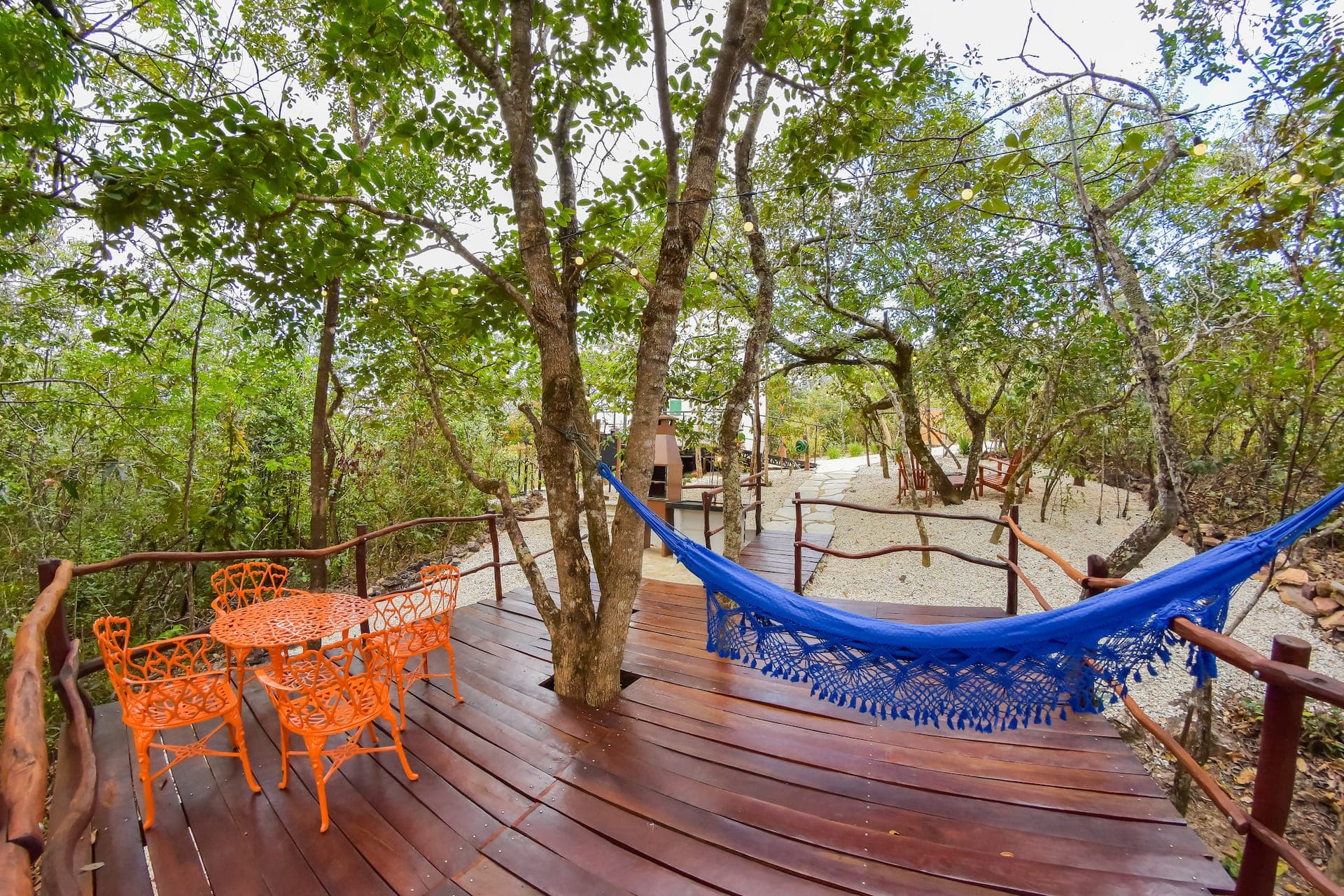 Vista de cima do deck, com banheira de hidromassagem, espreguiçadeiras e namoradeira redonda